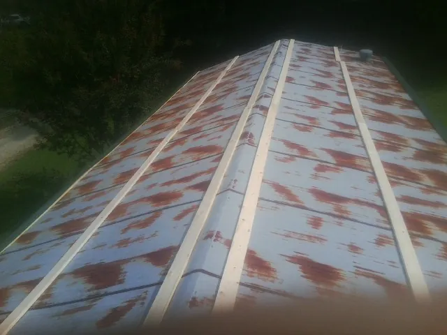 Rusted metal roof panels with new wood purlins before replacement — Storm Damage Roof Repair in Cliffside by Roofing Brothers