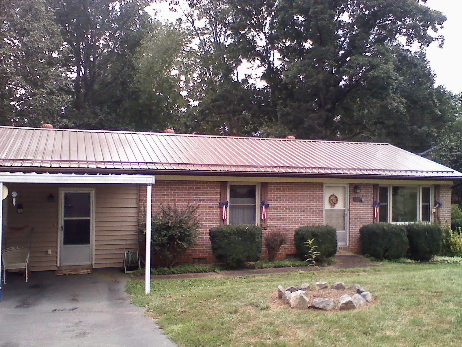 Bronze metal roof and carport on a brick ranch home — Roof Repair work by our crew in Cliffside